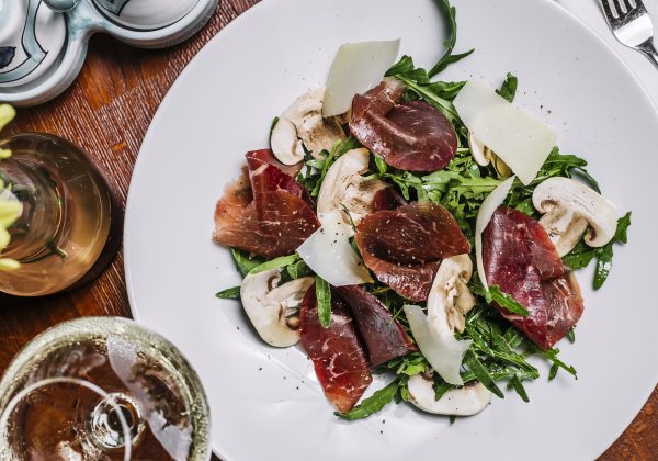 Ensalada de rúcula, jamón, queso curado y champiñones